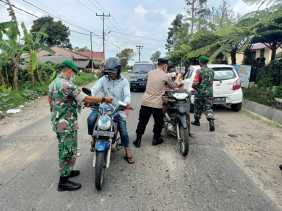 Cegah Penyebaran Covid-19, Babinsa Bersama Bhabinkamtibmas Bagikan Masker di Jalan Lau Kawar
