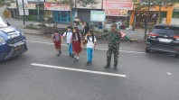 Peran Babinsa Berikan Keselamatan Bagi Anak Sekolah Dengan Bantu Menyeberangkan Jalan
