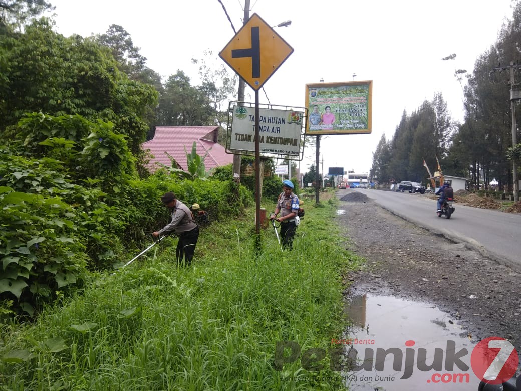 Kenyamanan Pengendara, Polres Karo Bersihkan Rumput Liar Ganggu Badan dan Marka Jalan