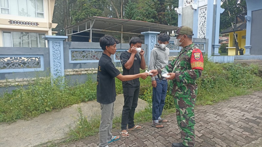 Peduli Kesehatan Masyarakat di Tengah Kabut Asap, Babinsa Koramil 03/BT Bagikan Masker di Berastagi
