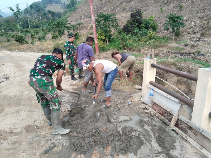 Babinsa Koramil 09/Laubaleng dan Warga Bersatu Perbaiki Jalan Rusak Akibat Hujan Deras