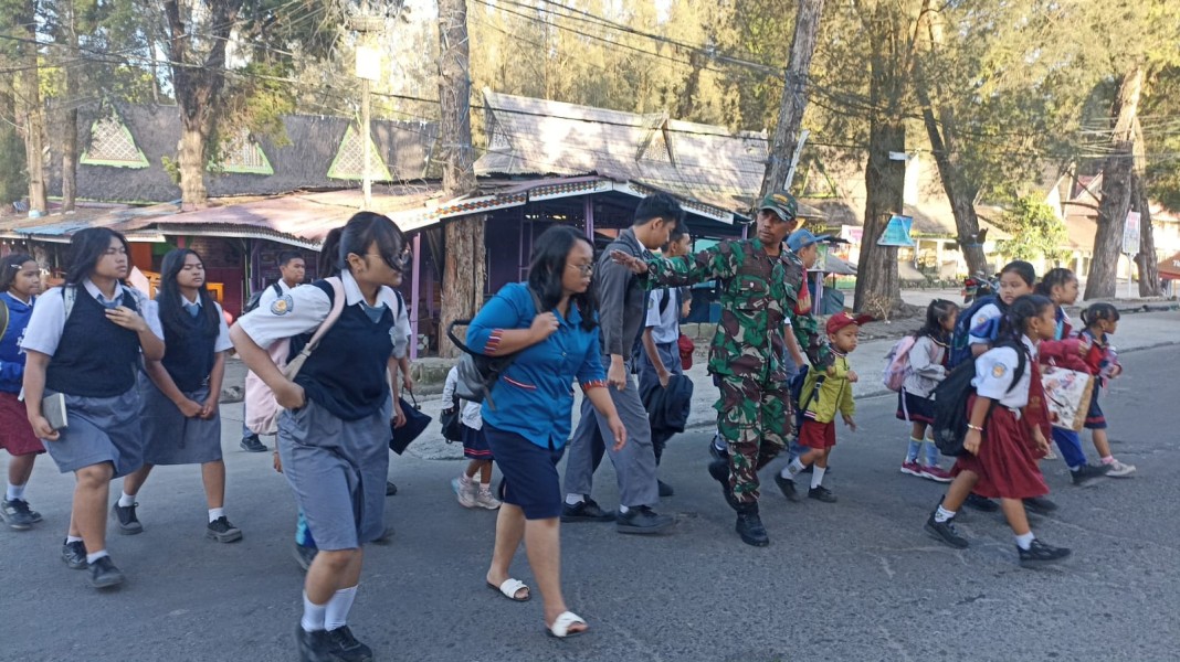 Humanisnya Babinsa Koramil 03/Berastagi Seberangkan Anak Sekolah Masehi