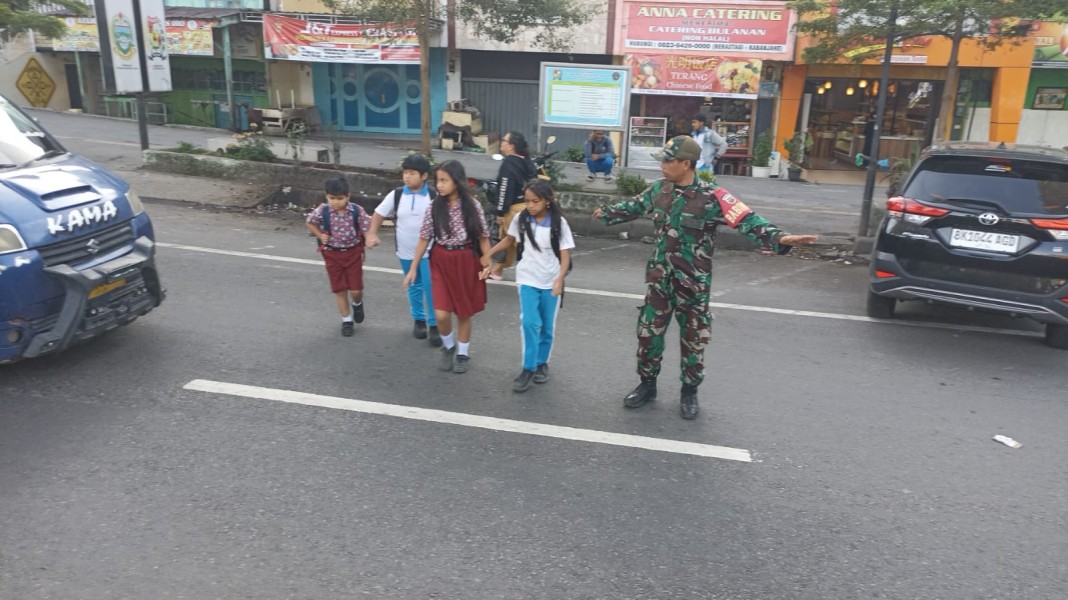 Peran Babinsa Berikan Keselamatan Bagi Anak Sekolah Dengan Bantu Menyeberangkan Jalan